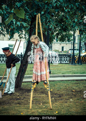 MOSCOW, RUSSIA - AUGUST 16, 2018: Historical festival Times and Epochs. Children learn to walk on wooden stilts. The little girl walks on stilts Stock Photo