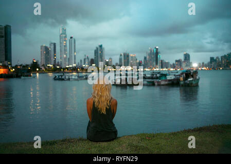 Woman from behind looking at view. Skyline of Punta Paitilla at night. Panama Bay, Panama City, Panama. RF, travel concept. Oct 2018 Stock Photo