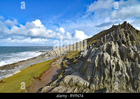 The Southwest Coast Path view towards Bull Point, (left side on horizon) from the rocky headland at Morte Point, North Devon, England Stock Photo