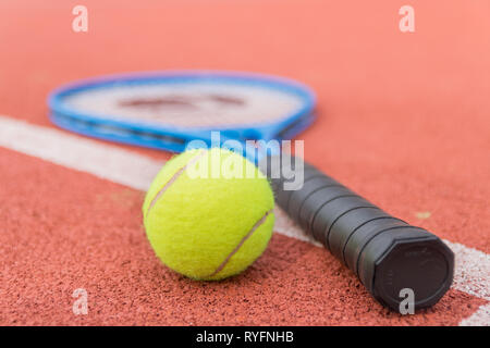 Isolated tennis ball and racket on the court Stock Photo