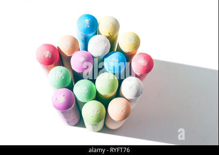 Pack of Jumbo Sidewalk Chalk, Assorted Colors, Bold Tips Casting Shadow on White Background. Top View. Stock Photo