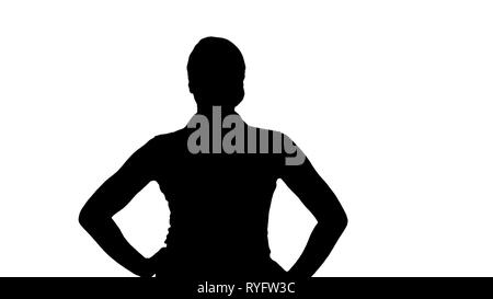 Silhouette Confident young pretty waitress walking with hands on hip. Stock Photo