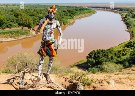 Omo Valley, Korcho village, Ethiopia - December 09, 2013: Unidentified Karo man with a gun and with the Omo River in the background. Stock Photo