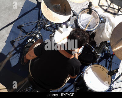 Greek drummer rehearsing in the sunshine before gig at a exclusive yacht club in Corfu, Kerkyra, Greece Stock Photo