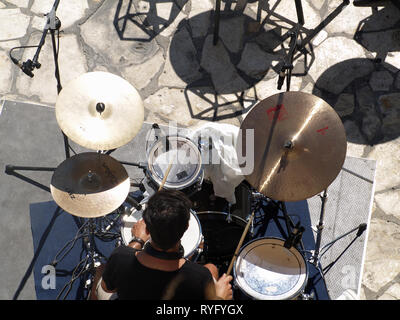 Greek drummer rehearsing in the sunshine before gig at a exclusive yacht club in Corfu, Kerkyra, Greece Stock Photo