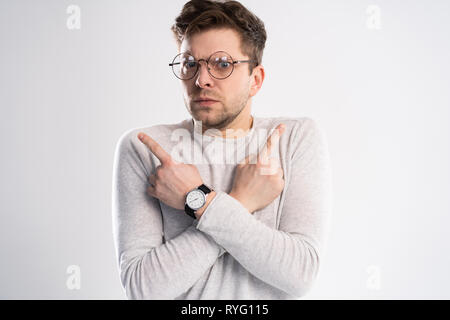 Young emotional careless man isolated on white background with copy space for text put his head on his fist and look aside stand in casual outfit Stock Photo