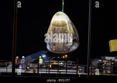 The SpaceX Dragon commercial crew capsule is off loaded by crane at port from the recovery ship, Go Searcher, after returning from the maiden flight to the International Space Station March 9, 2019 in Port Canaveral, Florida. Stock Photo