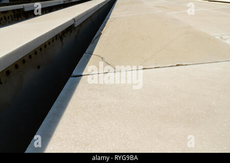 Wide concrete steps in strong sunlight, converging in distance. Abstract pattern. Stock Photo