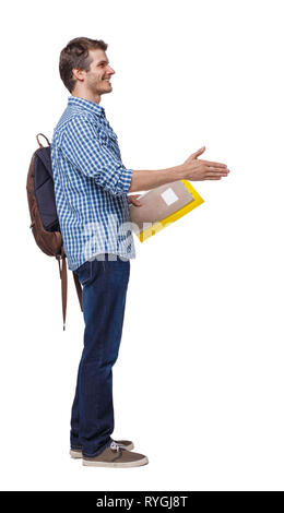 Side view of student man with the backpack and textbookswho stretches his hand for a handshake. Rear view people collection. backside view of person.  Stock Photo