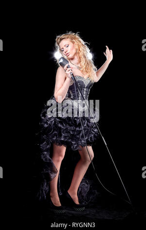 girl singer with microphone performing jazz composition. Stock Photo