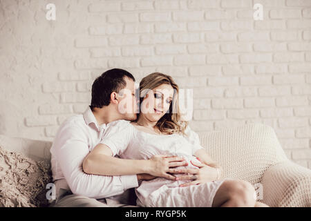 happy husband and wife sitting on sofa in living room Stock Photo