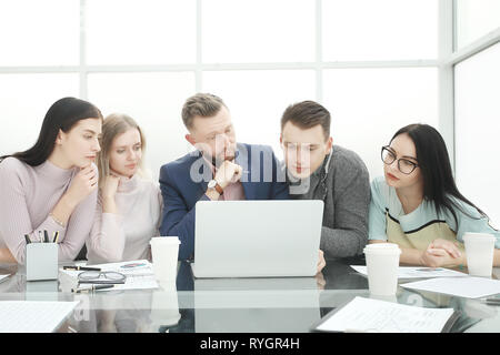 professional business team looks closely at the laptop screen Stock Photo