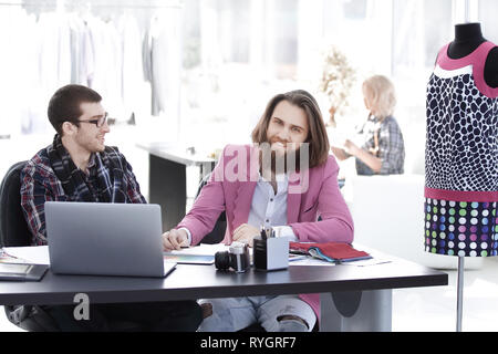 two fashion designers discussing designs of the new models Stock Photo