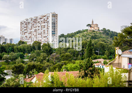 Saint-Joseph du Cabot chapel on Saint-Joseph hilltop in Le Cabot district and one of the residential buildings of the Residence Valmante in Marseille. Stock Photo