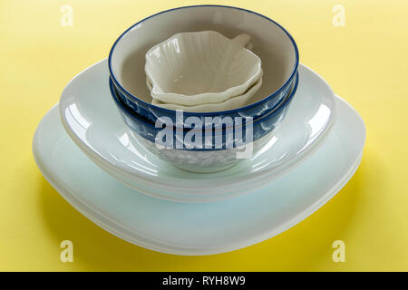 Different porcelain tableware on fresh yellow background Stock Photo