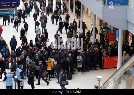 Waterloo station, London, England. March 12 2019. Commuters queue and block the entrance to the underground system at rush hour. Stock Photo