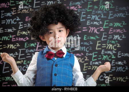 Primary school boy standing in front of the blackboard Stock Photo