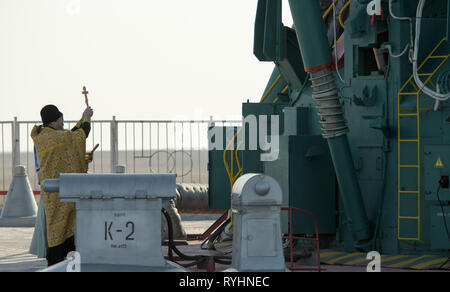 Baikonur, Kazakhstan. 14th Mar, 2019. Russian Orthodox Priest Father Sergei blesses the Soyuz MS-12 rocket on the launch pad as it prepares for liftoff at the Baikonur Cosmodrome March 14, 2019 in Baikonur, Kazakhstan. The Expedition 59 crew: Nick Hague and Christina Koch of NASA and Alexey Ovchinin of Roscosmos will launch March 14th for a six-and-a-half month mission on the International Space Station. Credit: Planetpix/Alamy Live News Stock Photo