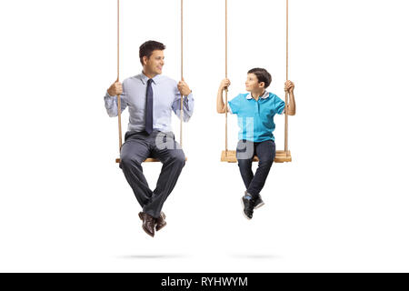 Full length portrait of a father and son sitting on swings and looking at eachother isolated on white background Stock Photo