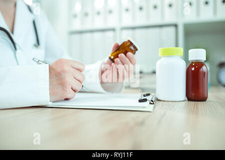 Doctor writing prescription for generic medicine drugs in medical office Stock Photo