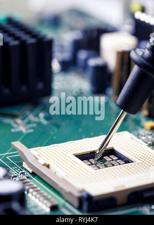 Close Up - Technician engineer measuring multimeter CPU socket computer motherboard (Technology repairing computer Hardware) Stock Photo