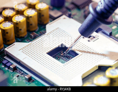 Close Up - Technician engineer measuring multimeter CPU socket computer motherboard (Technology repairing computer Hardware) Stock Photo