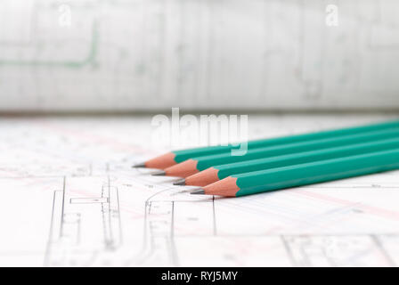 Architectural plans lying on drawing board with green pencils Stock Photo