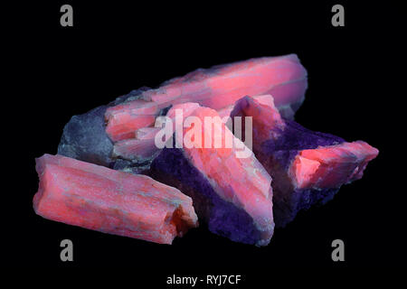 Crystals of major industrial lithium ore spodumene showing red fluorescence in ultraviolet light (365 nm).   Sample from Haapaluoma Finland. Stock Photo