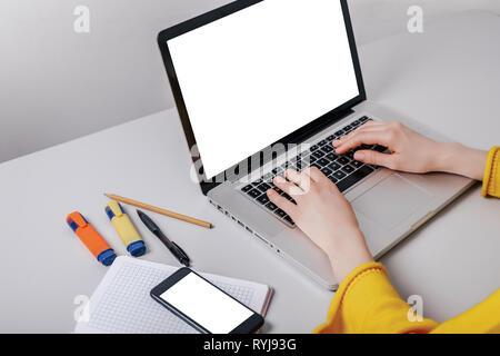 Closeup view woman hands using mobile smartphone and laptop. Space mockup for design layout. Light interior. Stock Photo