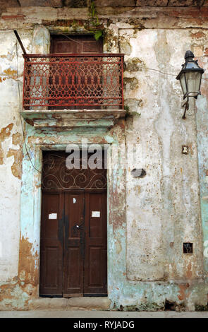 The front door and balcony of a dilapidated residential building in Old Havana, Cuba. Many of the city's historic buildings are in need of repair. Stock Photo