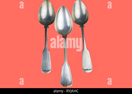 Old spoons on a living coral background. Color of the year 2019 living coral. Top view. Free space for text. Stock Photo