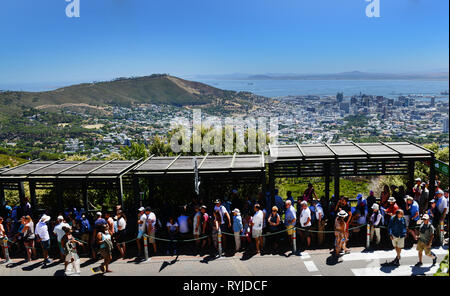 Tourist standing in a long line for the cable car that goes up to the top of the Table Mountain in Cape Town. Stock Photo