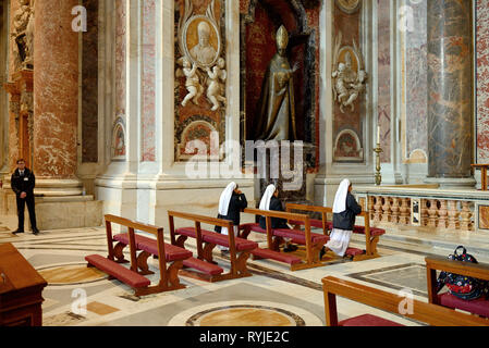 Three Nuns Praying in Saint Peter's Basilica, Church or Cathedral, Vatican, Rome, Italy Stock Photo