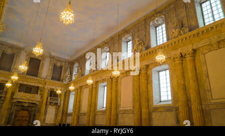 The hanging golden chandelier inside the castle in Stockholm Sweden with the long table in the center Stock Photo
