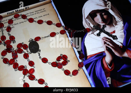 Christian Rosary on a digital tablet.  Catholic prayer : Ave Maria. Stock Photo