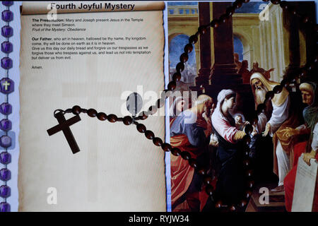 Christian Rosary on a digital tablet.  Catholic prayer. The Fourth Joyful Mystery : the Presentation. Stock Photo