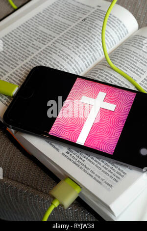 Paper Bible and digital Bible app on smartphone. Stock Photo