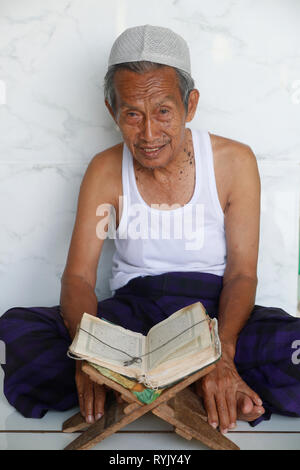 Jamiul Azhar mosque.  Muslim man reading an old Quran.  Chau Doc. Vietnam. Stock Photo