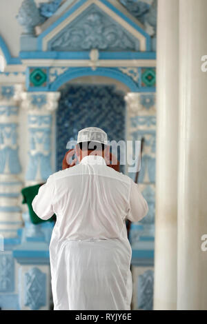 Masjid Nia'mah mosque.  Muslim man praying in front of the  minbar. Chau Doc. Vietnam. Stock Photo