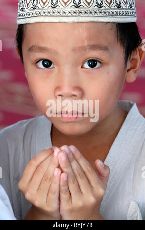 Masjid Ar-Rohmah mosque. Young muslim boy praying.  Chau Doc. Vietnam. Stock Photo