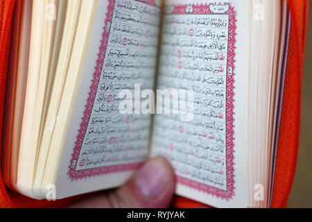 Muslim man reading an Arabic Holy Quran (Koran). Stock Photo