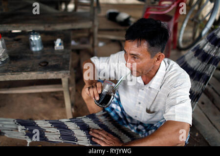 Vietnamese man drinking coffee in hammock. Chau Doc. Vietnam. Stock Photo