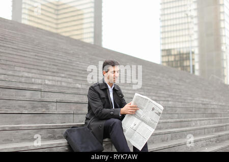 effect. Tutor dressed in gray coat sitting on rung and read morning newspaper. Articles pleased man and caused smile. Male turn edition for read any g Stock Photo