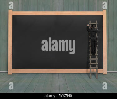 Businessman climbing ladder drawing on blank black board with dark green wood wall and floor background Stock Photo