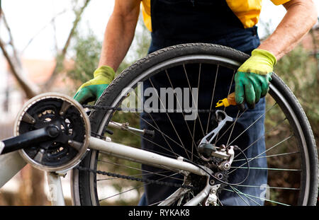 Man lubricating bicycle chain and maintaining for the new season Stock Photo