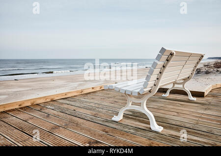 Empty bench on the beachfront, color toned picture. Stock Photo