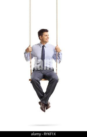 Full length portrait of a young professional man sitting on a swing and looking away isolated on white background Stock Photo