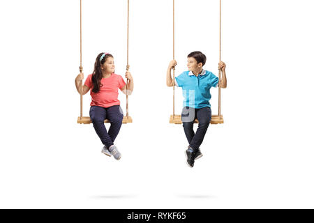 Full length shot of a little boy and girl on swings looking at each other isolated on white background Stock Photo