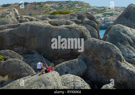 Rhodes, Greece - September 17, 2017: Young girl next to a guy takes a selfie in a mountainous area on the sea coast Stock Photo