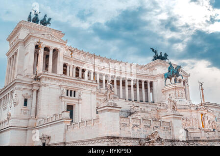 The Altare della Patria in Piazza Venezia, a war memorial monument, in marble and stone, with statues and ancient columns, under a cloudy sky Stock Photo